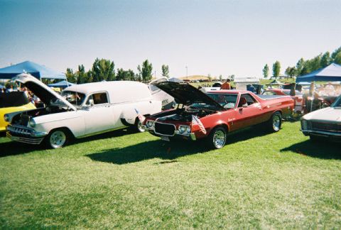 1972 Ford Ranchero - A red pickup truck is parked on a grassy field with its hood open.