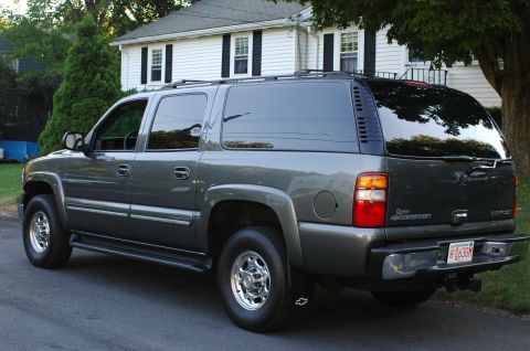 2001 Ford Crown Victoria - This Chevrolet Suburban is seen from the rear quarter angle, parked in front of a residential house.