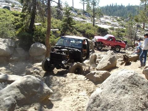 1996 Ford Bronco - Off-road vehicles tackle a challenging rocky path in a wooded, mountainous area.