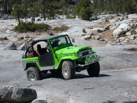 1996 Ford Bronco - Toyota Land Cruiser FJ40 navigates a rocky trail under a clear sky.