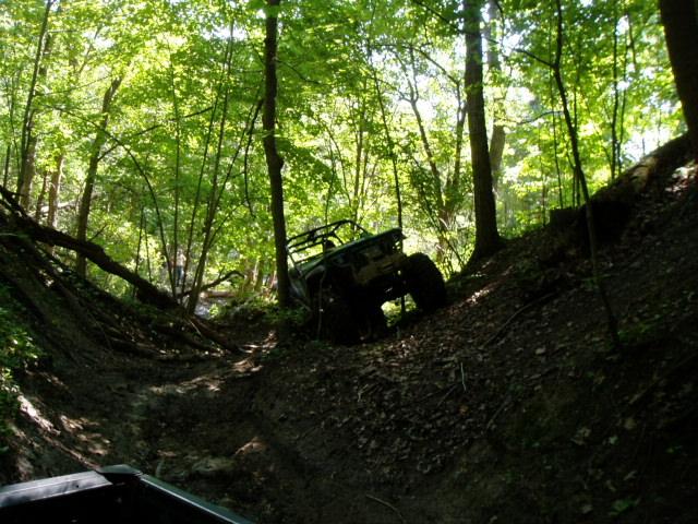 Off-road vehicle on a muddy incline in a forest