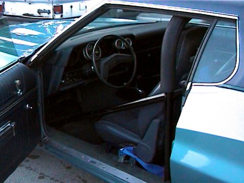 1977 Ford F-150 - Modified car interior with roll cage and racing seat. The dashboard and steering wheel are visible.