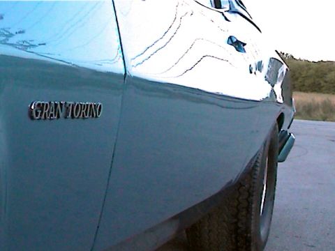 1977 Ford F-150 - Close-up of a blue car's side panel, a 'GRAN TORINO' emblem.