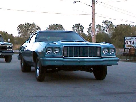 1977 Ford F-150 - This teal 1977 Ford Gran Torino features a prominent vertical grille and dual headlights.