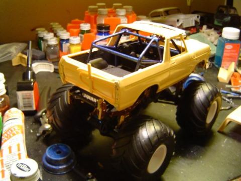 1979 Ford Bronco - Model kit of a monster truck in progress, with various paints and tools on the workbench.