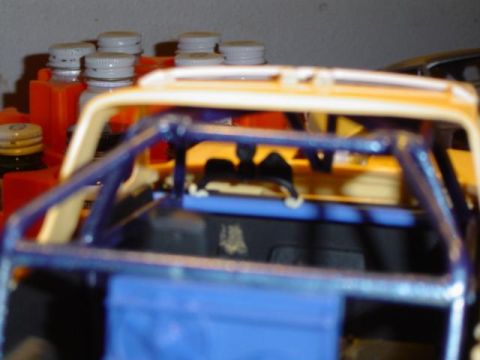 1979 Ford Bronco - This is a model of an SUV interior, a blue roll cage and yellow exterior paint.