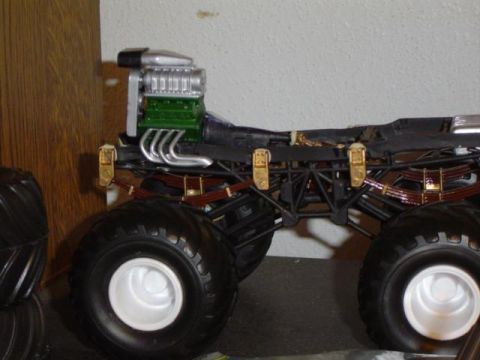 1979 Ford Bronco - Model of a monster truck a prominent green engine and oversized tires, viewed from the side.