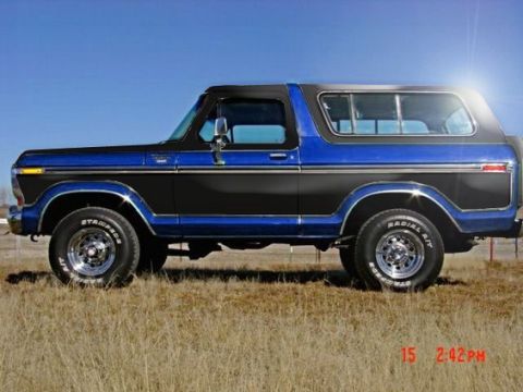1979 Ford Bronco - This two-tone Ford Bronco is shown from the side against a clear blue sky.