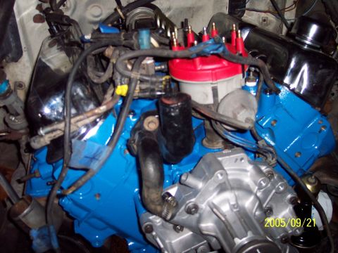 1985 Ford Bronco - The engine bay shows various components, including a freshly painted blue engine block and a red distributor cap.
