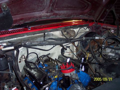 1985 Ford Bronco - The engine bay of a 1985 Ford Bronco shows a blue engine block and red distributor cap, with the hood open.