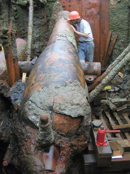 1988 Ford Bronco - Excavation of a large, unidentified, corroded metal object with a person examining it.