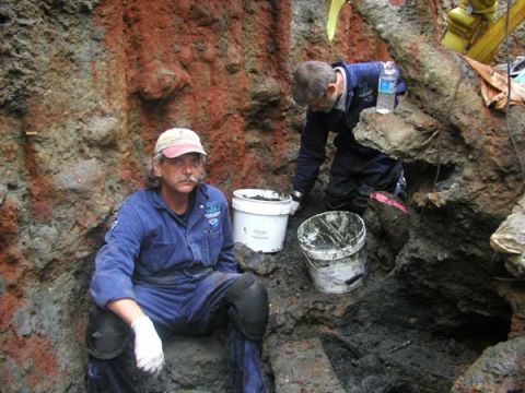 1988 Ford Bronco - Workers are excavating a deep trench, with one man sitting and the other actively digging.