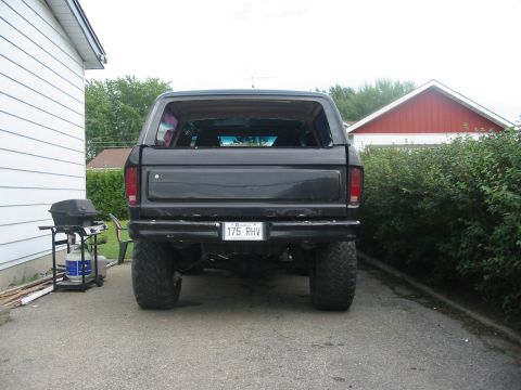1985 Ford Bronco - Rear view of a black Ford Bronco with aftermarket wheels and tires.