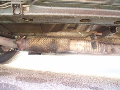1993 Ford Taurus - Close-up of a vehicle's exhaust system, focusing on the flexible pipe and muffler.