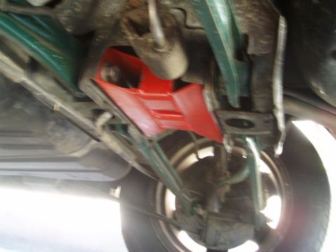 1993 Ford Taurus - Underside view of a vehicle's suspension system with a bright red brace.