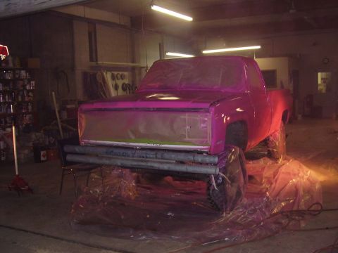 1981 Chevrolet C/K Pickup - A pickup truck is covered in plastic sheeting, likely for painting, in a garage setting.