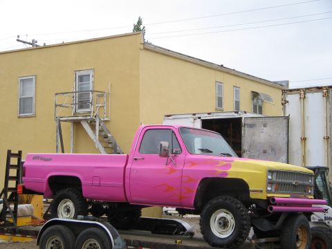 1981 Chevrolet C/K Pickup - This pickup truck features a two-tone paint job with flame decals and is parked on a trailer.
