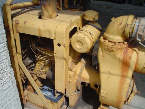 1966 International School Bus - Close-up of a yellow industrial engine, showing its exhaust pipe, air filter, and a battery.