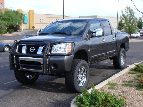 2005 Nissan Titan - This lifted Nissan Titan pickup truck features a chrome grille guard and aftermarket wheels.