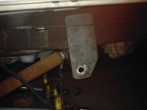 1978 Ford Bronco - Metal bracket attached to vehicle frame, with a rusty pipe in the foreground.