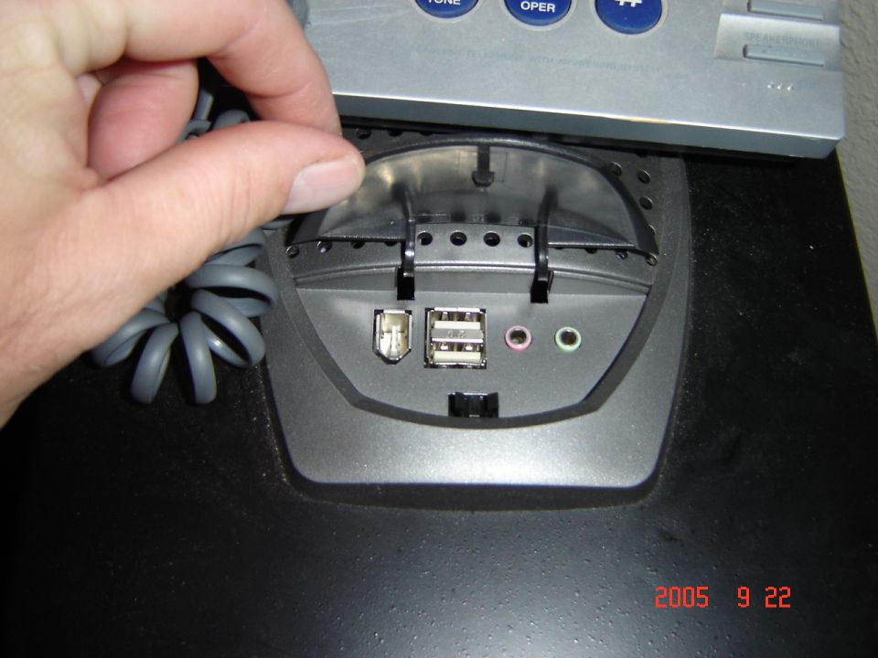 Computer ports with USB and audio jacks, hand reaching to open cover