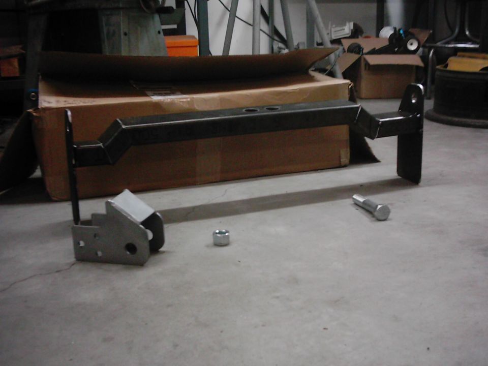 Trailer hitch receiver and a bolt and nut on a concrete floor