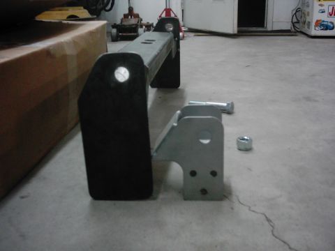1978 Ford Bronco - A metal bumper part is shown in a garage setting, with a cardboard box and tools in the background.