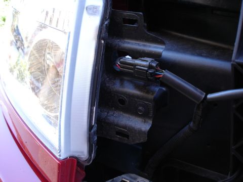 2005 Nissan Titan - Close-up view of a vehicle's headlight assembly and its associated wiring harness.
