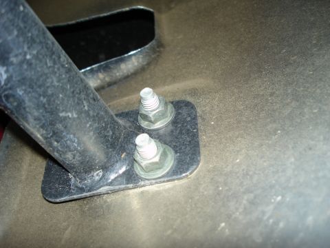 2005 Nissan Titan - Close-up of a metal bracket attached with bolts, likely a vehicle part.