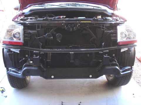 2005 Nissan Titan - The front end of a truck is exposed, with the bumper detached and the radiator and fan visible.