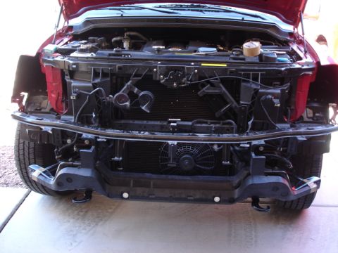 2005 Nissan Titan - Front end of a red truck, likely a 2004 model, with the bumper removed for service.
