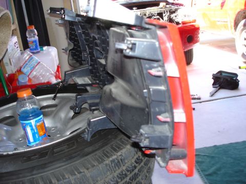 2005 Nissan Titan - Close-up of a vehicle bumper assembly and tire, with various bottles and tools visible.