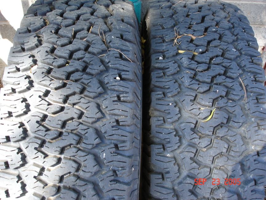 Two all-terrain truck tire treads side by side on concrete, dated Sep 23 2005
