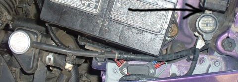 1994 Ford Probe - Close-up view of engine bay components, including a battery and coolant reservoir.