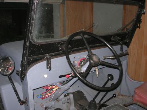 1954 Jeep Wrangler - The interior of a 1954 Jeep shows exposed wiring and a gray painted dashboard.