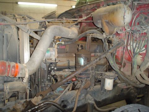1966 International School Bus - Close-up view of a truck's engine compartment, showing various hoses, filters, and mechanical parts.