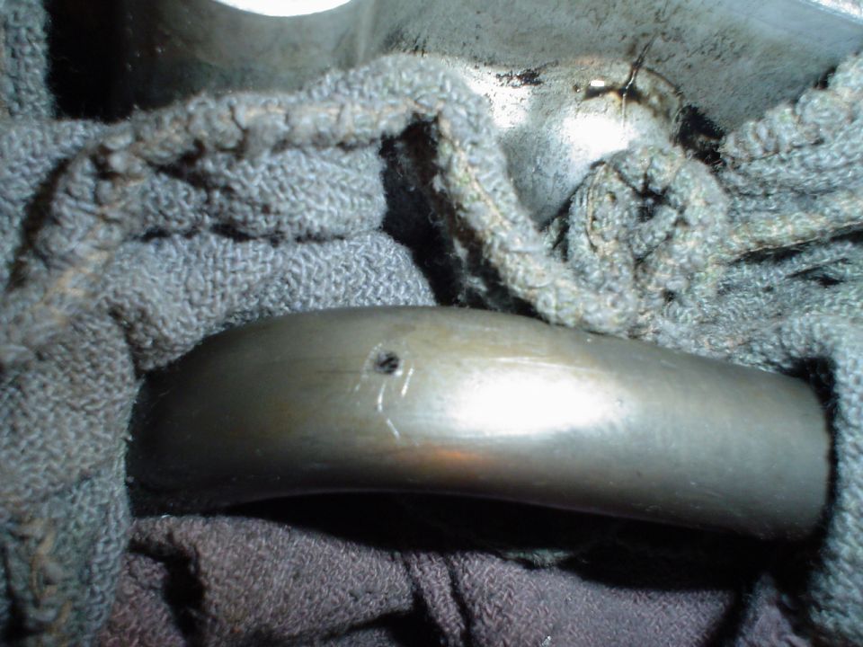 Macro of a curved steel rocker arm with oil hole and polished wear face on shop rags