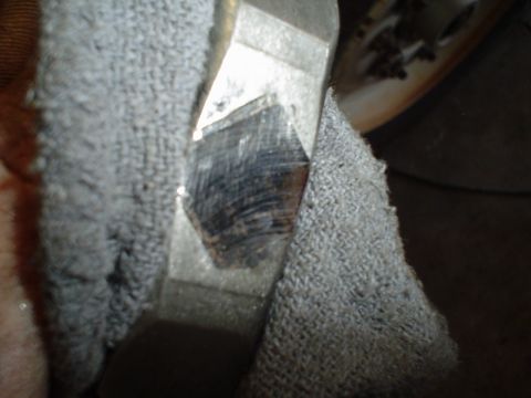 1966 International School Bus - A metal part, possibly a gear or fitting, is held by a textured gray fabric material.
