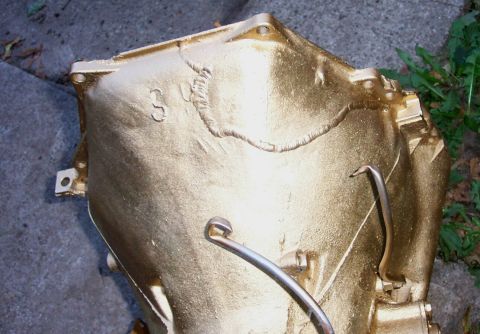 1978 Ford Bronco - A gold-painted transmission casing is shown, with visible welds and a stamped number '3' on its surface.
