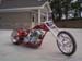 1979 Ford Bronco - A custom chopper motorcycle is parked on a paved surface in front of a building.