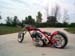 1979 Ford Bronco - A custom chopper motorcycle is shown from the side on a paved road with trees in the background.