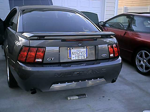 2004 Ford Mustang GT rear view with license plate NOV2305 119727E. Another car is parked to the right