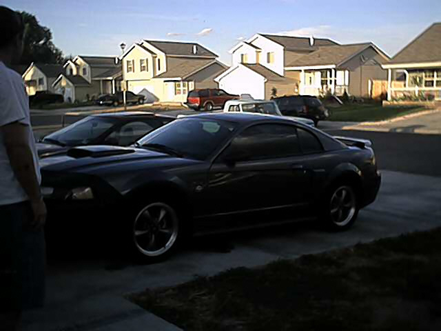 Dark 2004 Ford Mustang coupe, 3/4 front view, parked in driveway