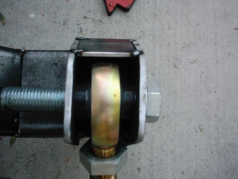 1978 Ford Bronco - Close-up of a metal suspension component, showing a threaded bolt and bushing against a concrete surface.