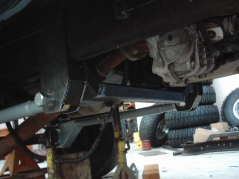 1978 Ford Bronco - Vehicle undercarriage with suspension and drivetrain components visible, supported by jack stands.