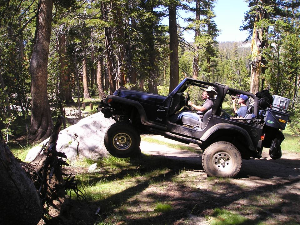 Black Jeep Wrangler TJ navigating rocky terrain