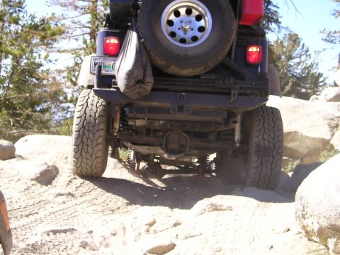 1989 Ford Bronco - A Jeep Wrangler navigates a challenging rocky terrain, its off-road capabilities.