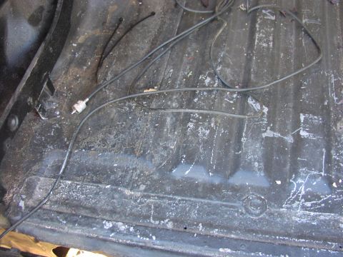 1979 Ford Bronco - The ribbed floor of a vehicle's cargo area shows some wear and tear, with wires and zip ties present.
