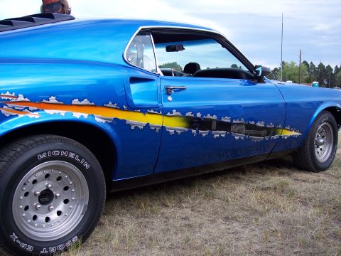 1972 Ford Ranchero - This blue coupe features a unique ripped metal graphic along its side and louvers on the rear window, suggesting a 1970s model.