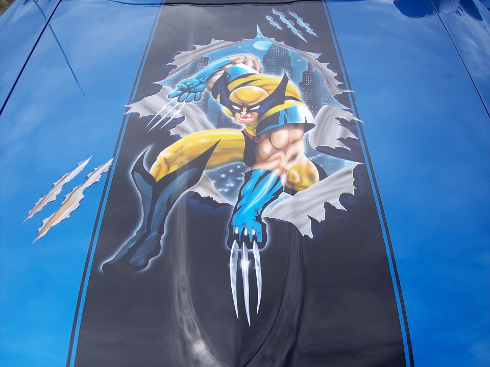 Blue car hood with black stripe and airbrushed Wolverine graphic bursting through